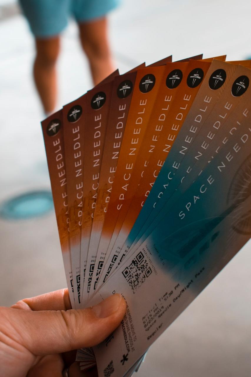 person holding brown, blue, and white tickets